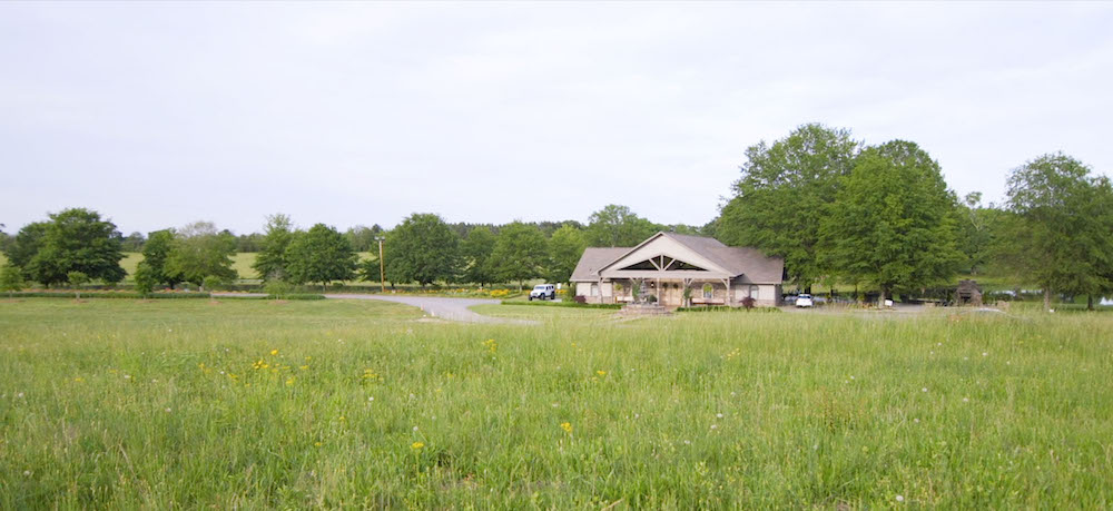 reception hall sitting off to the side of a meadow