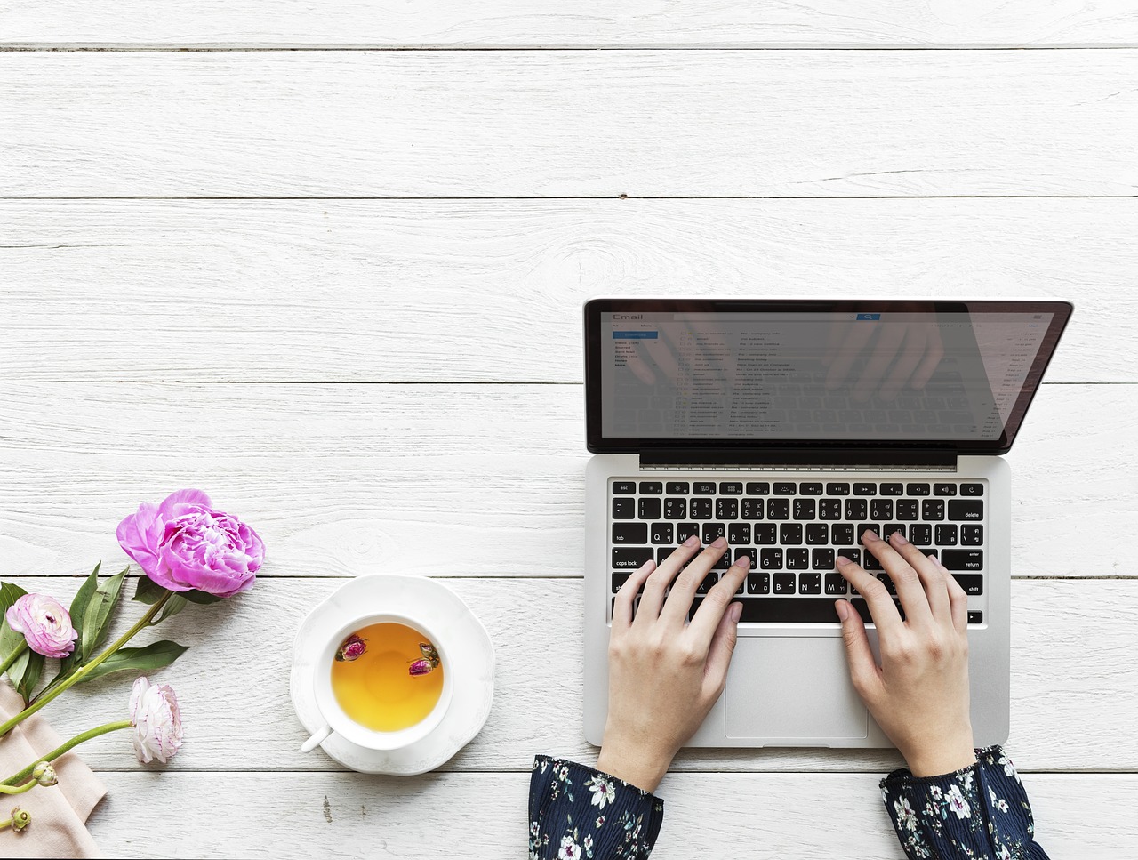 a woman types an email on a laptop wedding email address