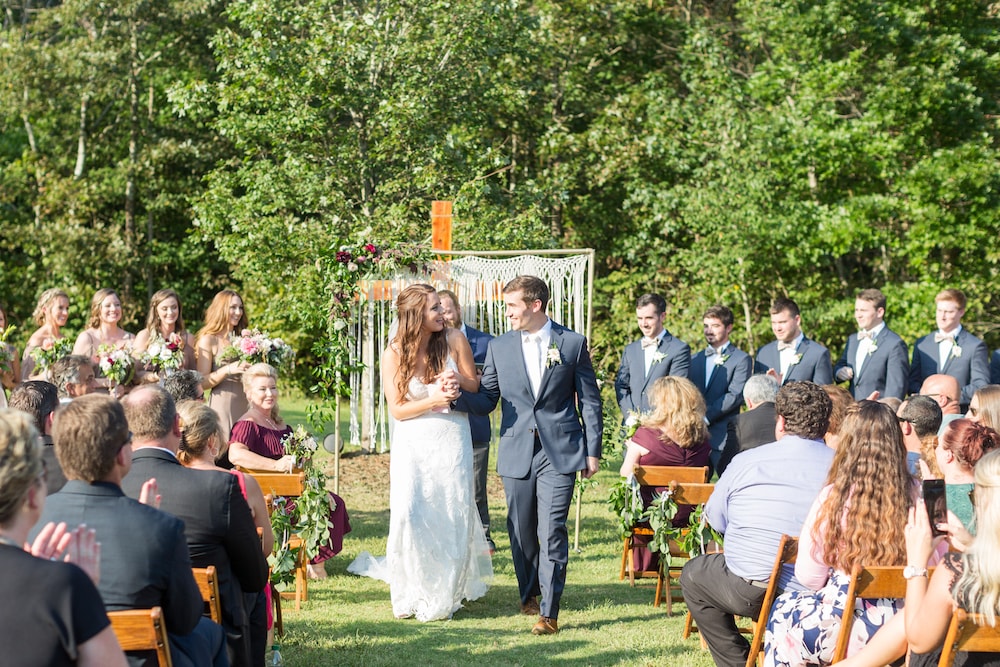 groom and his bride walk down the aisle